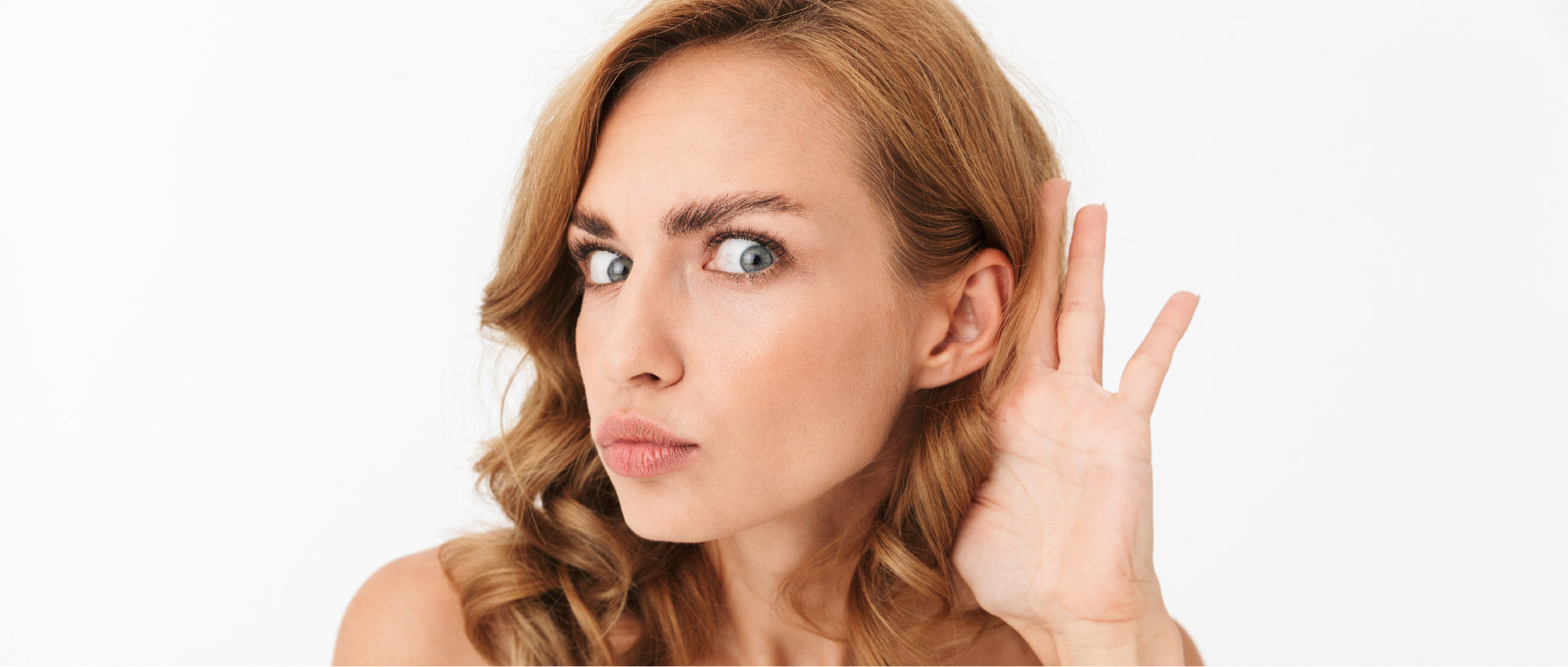 Nahaufnahme einer Frau mit blonden Haaren, die Hand ans Ohr hält und konzentriert zuhört vor weißem Hintergrund​​​​​​​​​​​​​​​​​​​​​​​​​​​​​​​​​​