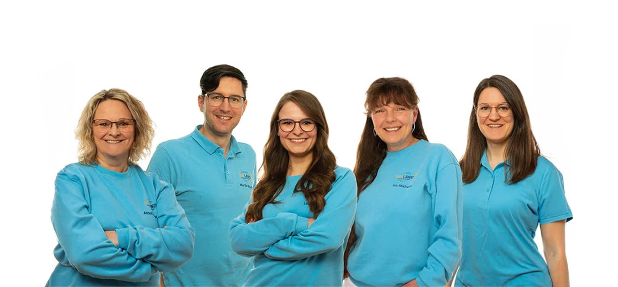 Fünf lächelnde Personen tragen blaue Firmenpullover und Poloshirts vor weißem Hintergrund, Teamfoto mit freundlicher Stimmung​​​​​​​​​​​​​​​​​​​​
