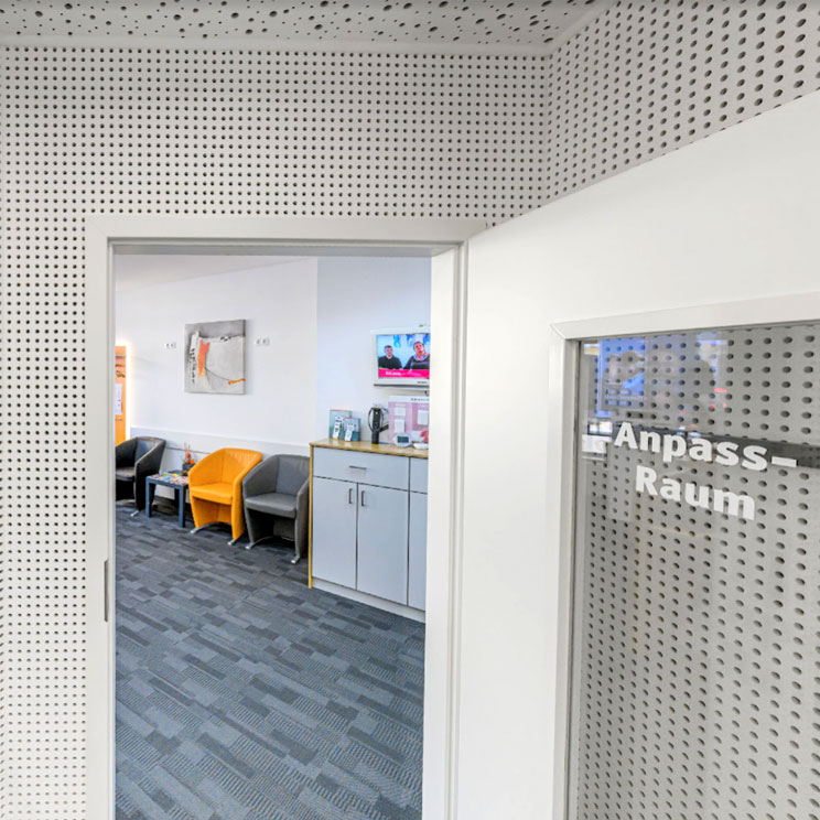 Moderner Wartebereich mit bunten Sesseln und Anpassraum in einem Hörgeräteakustik Geschäft in Waldsassen.​​​​​​​​​​​​​​​​​​​​​​​​​​​​​​​​​​​​​​​​