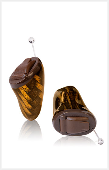 Nahaufnahme von zwei braunen Im Ohr Hörgeräten mit Muster auf weißem Hintergrund für bessere Hörhilfe.​​​​​​​​​​​​​​​​​​​​​​​​​​​​​​​​​​​​​​​​​​​